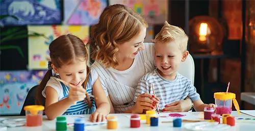 Edukacyjne gry i zabawy dla dzieci. Mama pokazuje dzieciom jak rysować i malować farbami.